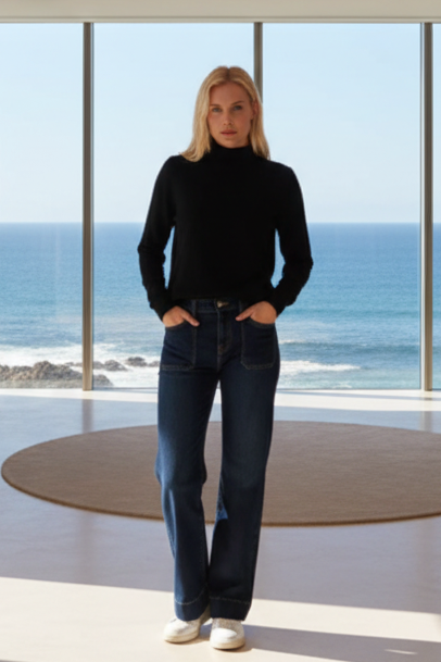Woman wearing a black turtleneck sweater and blue jeans on a beige background